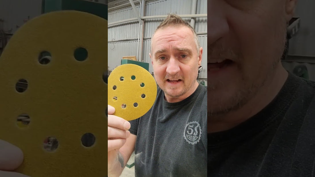 Christopher Webb holding an Aiyard 5-inch 8-hole gold hook and loop sanding disc in his shop